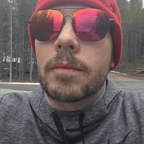 Doug in a red beanie and mirrored sunglasses, biking in Yellowstone